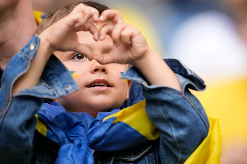 Ukrainian child makes a heart sign ahead of Slovakia vs Ukraine match